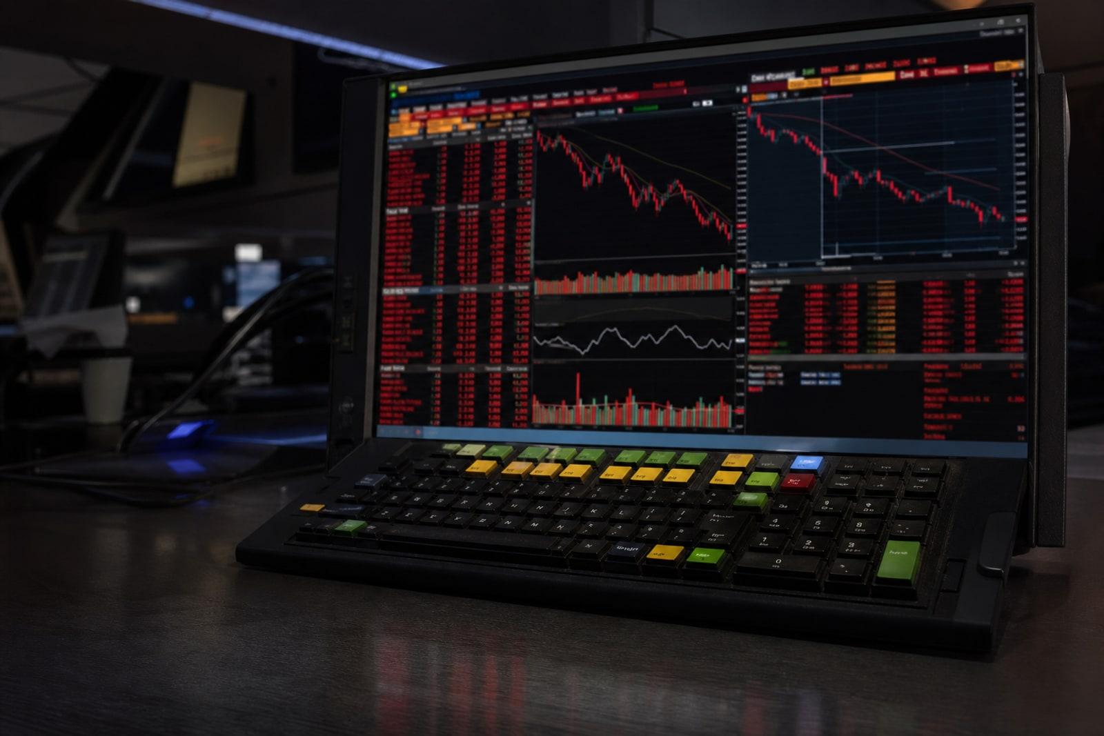 A darkened trading terminal screen filled with red, falling tickers and charts for AI and semiconductor stocks.