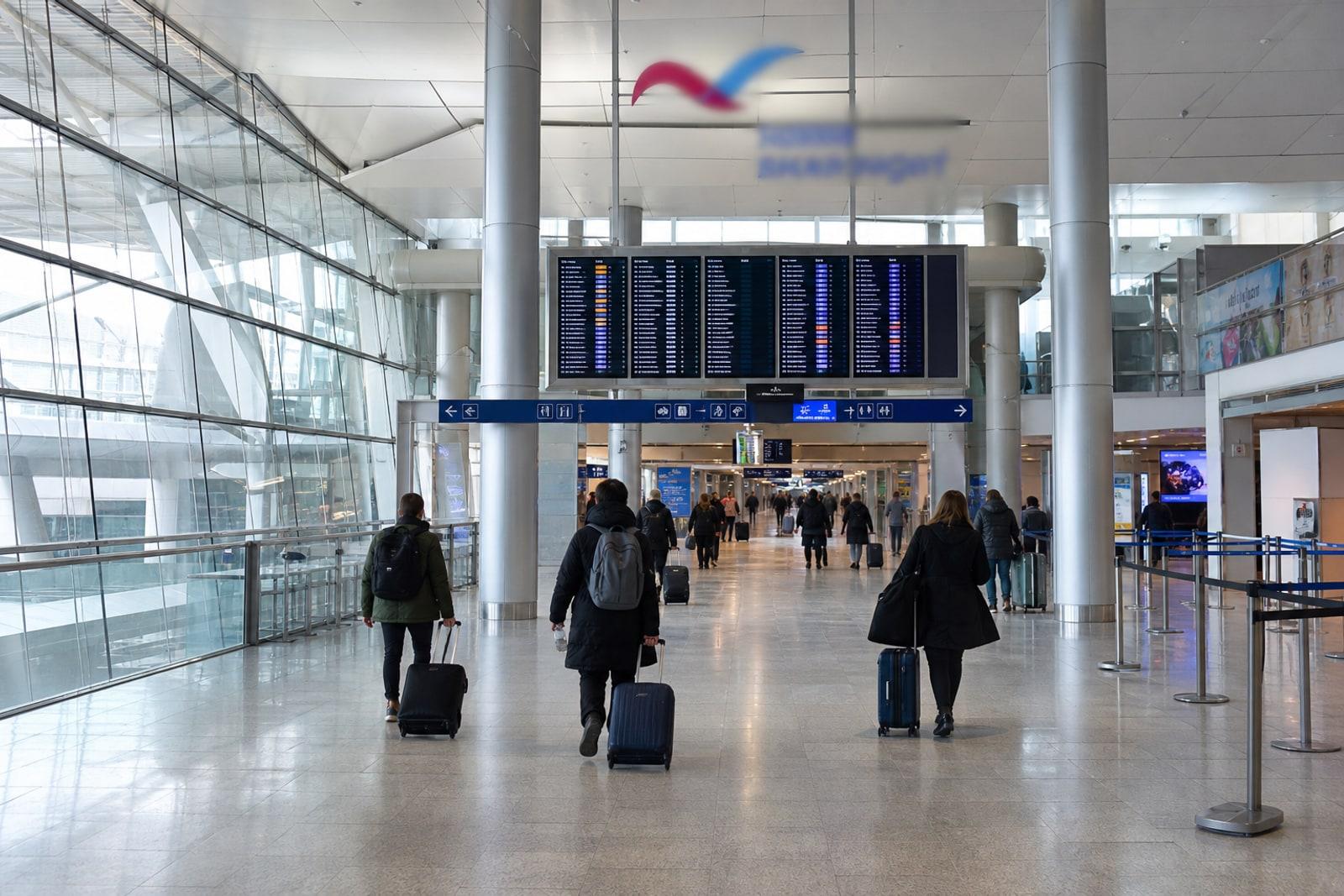 Flight-information boards in the glass-and-steel departure hall of Luxembourg Airport Terminal A.