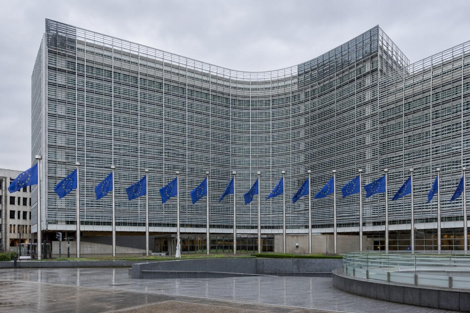 The European Commission's Berlaymont headquarters in Brussels behind a row of European Union flags.