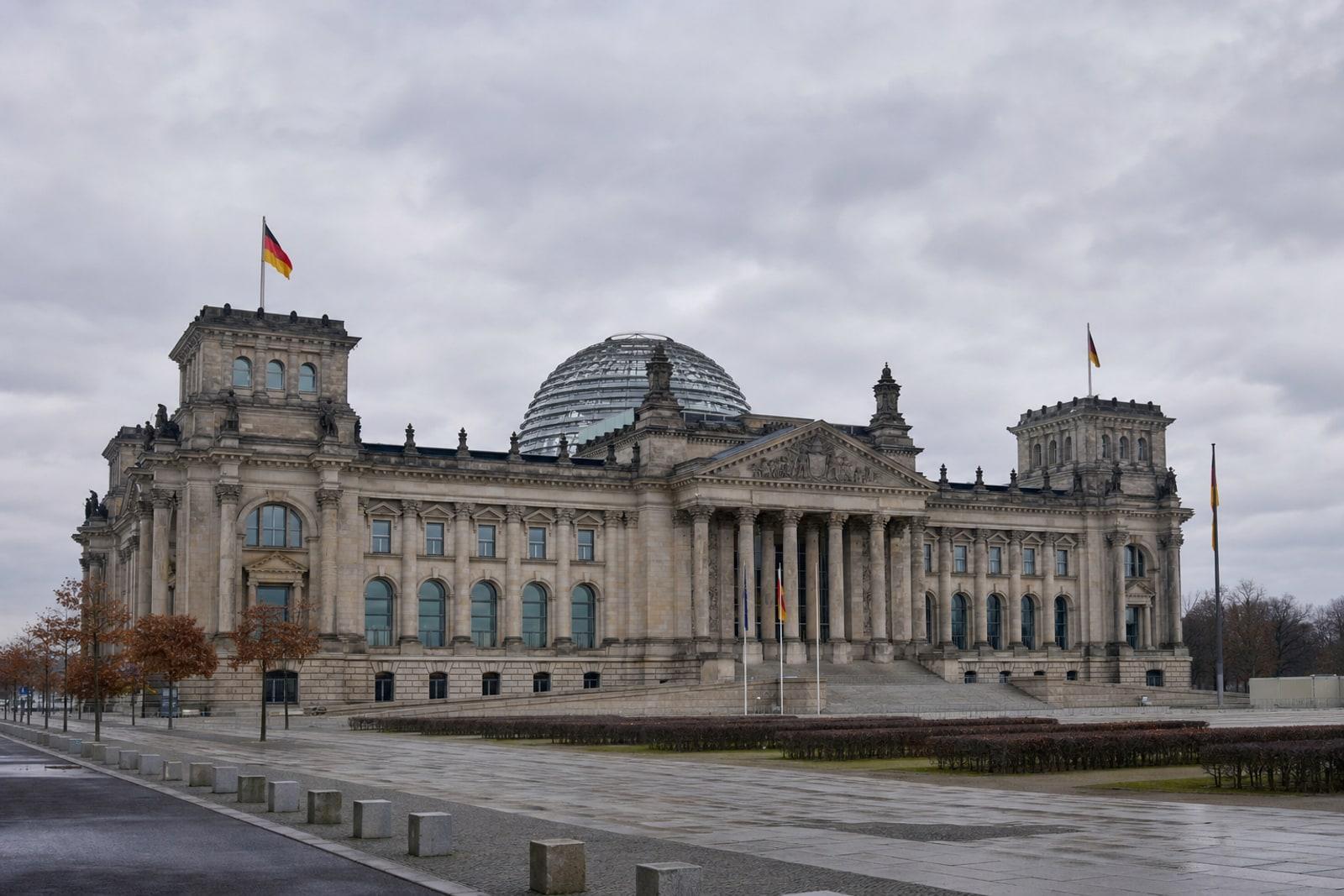 The Reichstag building in Berlin, home of the German parliament, under an overcast sky.