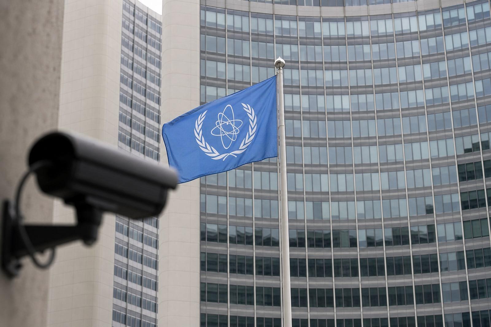 The light-blue flag of the International Atomic Energy Agency, showing two olive branches around a stylised atom, outside the agency's Vienna headquarters.