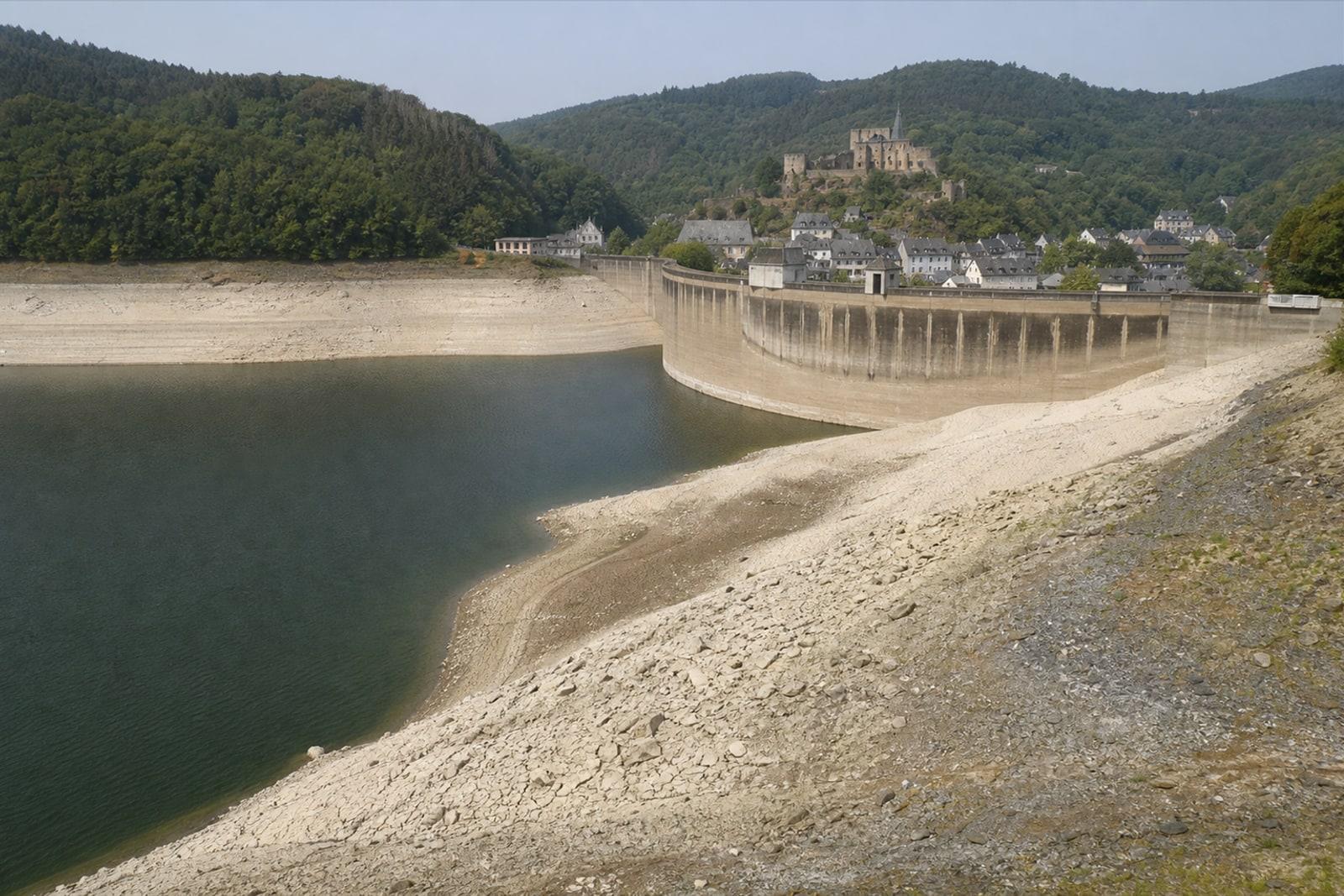 The Upper Sûre reservoir at Esch-sur-Sûre with a lowered, drought-exposed shoreline below forested hills (AI-generated illustration).