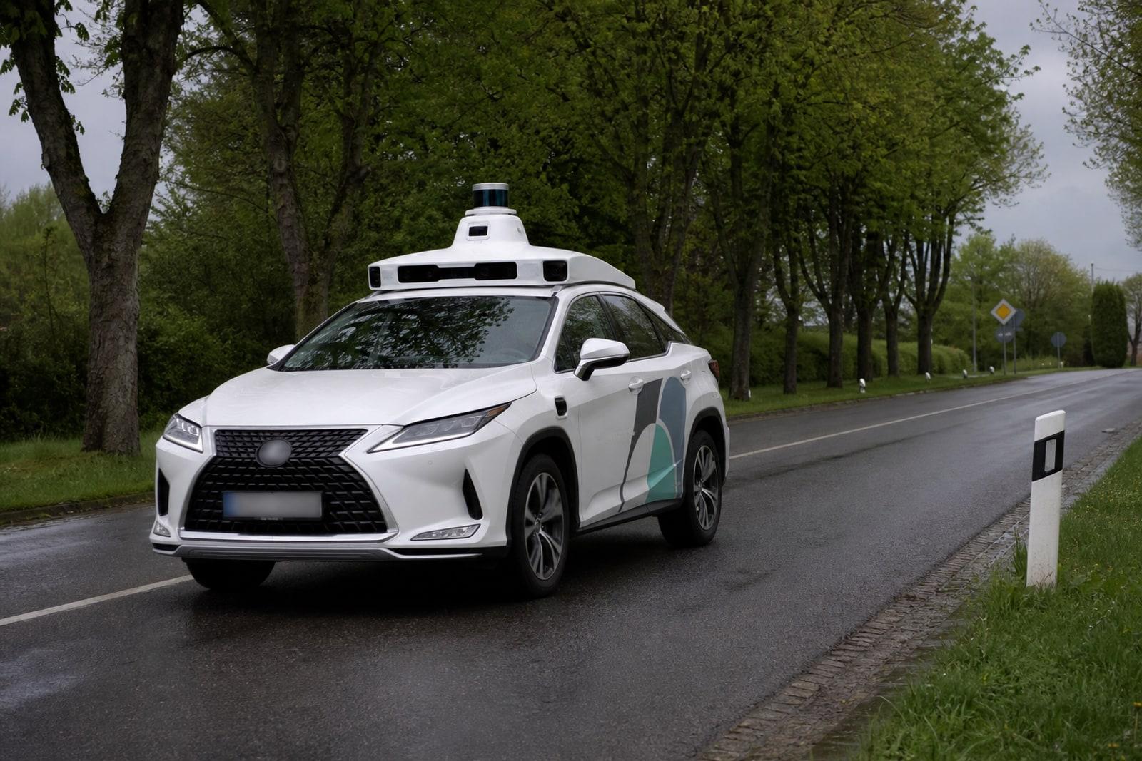 A white Pony.ai self-driving test car fitted with a roof-mounted lidar-and-camera sensor pod on a quiet tree-lined road in eastern Luxembourg.
