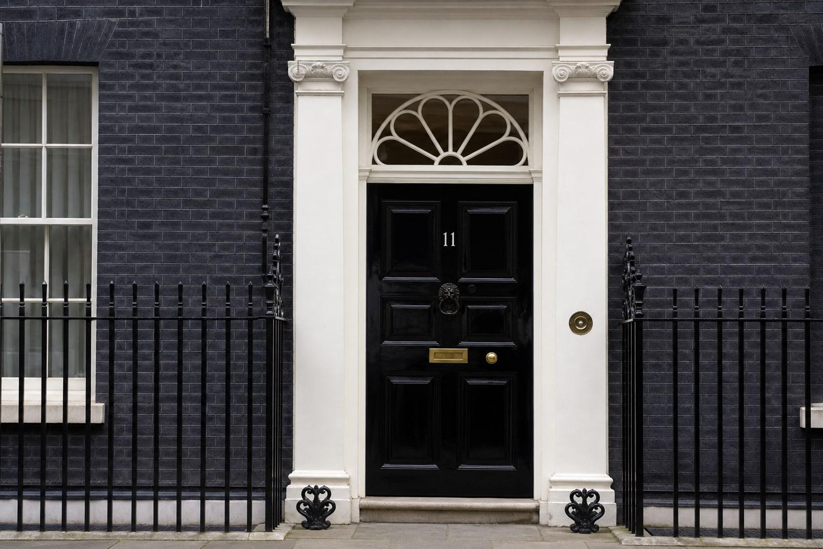 The black front door of 11 Downing Street in London, with the number 11 and iron railings