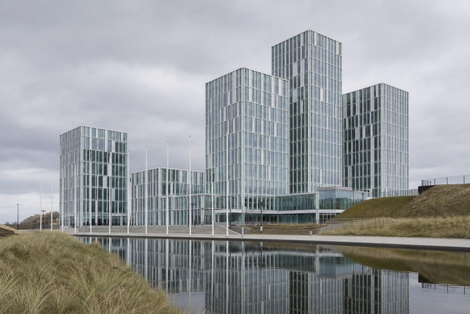 The glass towers of the International Criminal Court headquarters in The Hague under an overcast sky