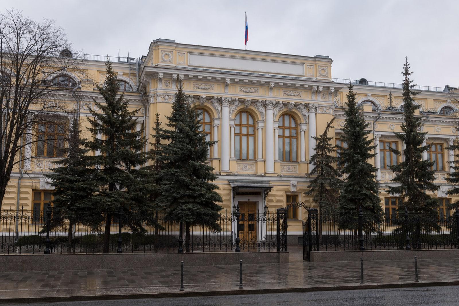 The ochre-and-white neoclassical headquarters of the Bank of Russia in Moscow under grey light.